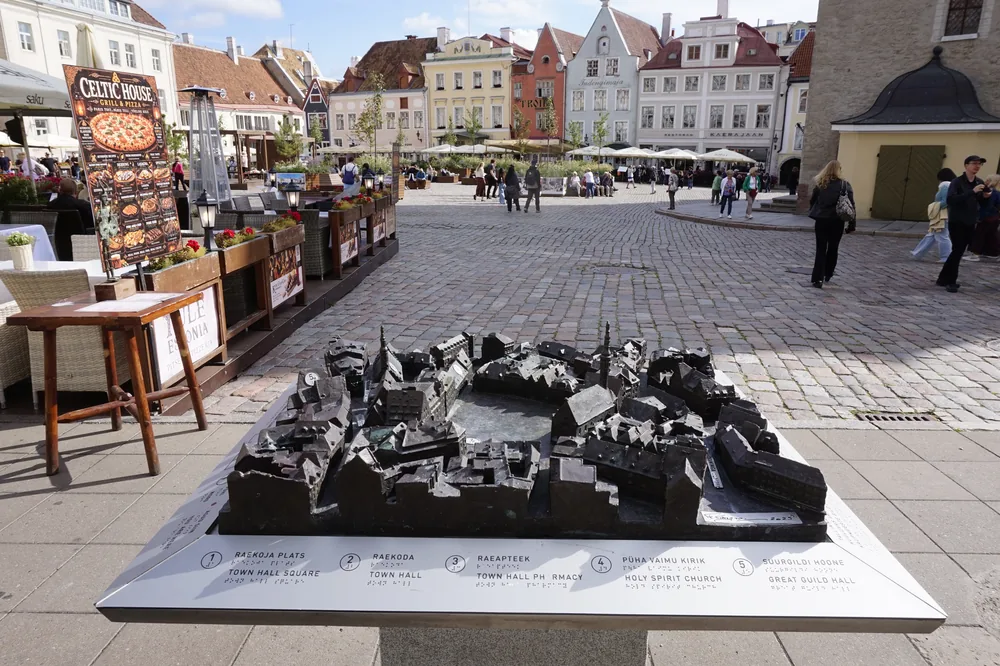Makieta Starego Miasta w Tallinie z brązu, w tle rynek i kamienice