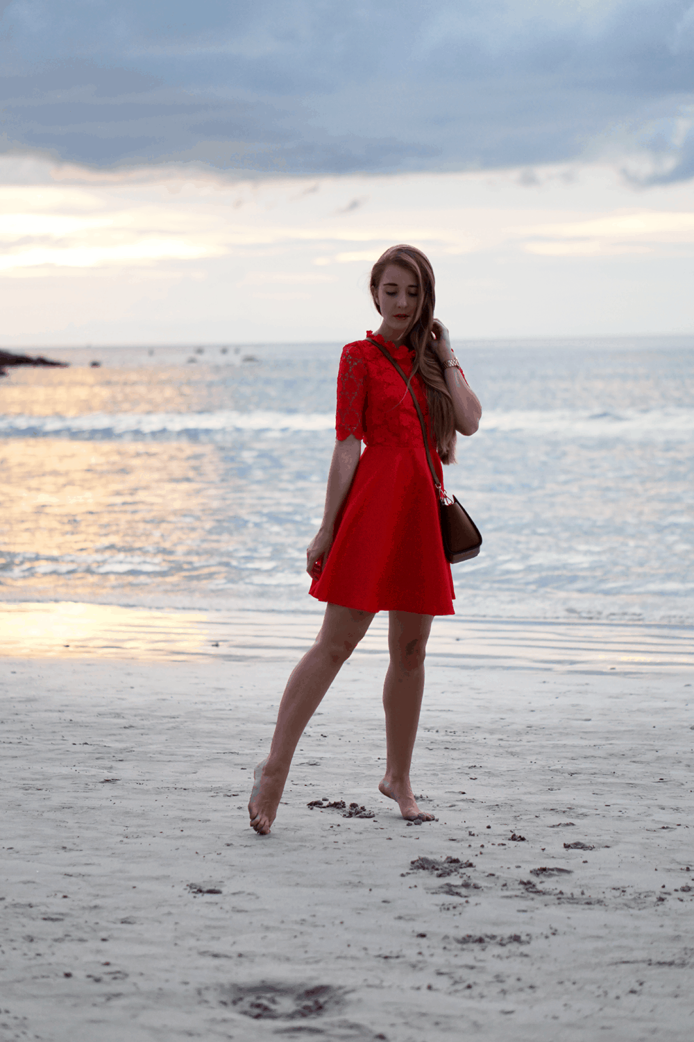 romantyczny zachód słońca spacer po plaży czerwona sukienka